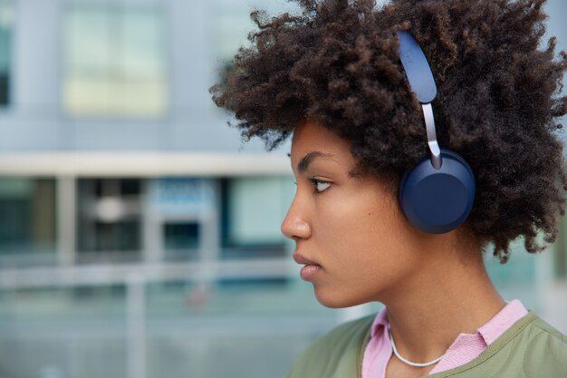 woman listens music headphones enjoys interesting plot audio book looks seriously forward walks modern urban setting 273609 552908023113346783685381